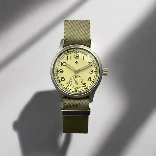 Aeschbach x Enoksen 'Fly' E03/T Dirty Dozen Automatic watch, 36mm, cream dial, shown with  a Khaki Seatbelt NATO strap.