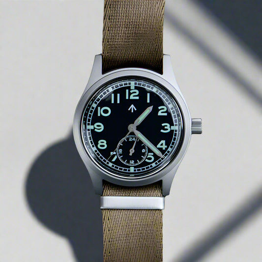 Aeschbach x Enoksen 'Fly' E03/H Dirty Dozen Meca-Quartz watch, 36mm, black dial, shown with a Khaki Seatbelat  NATO strap.